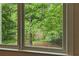 View of a pond surrounded by a lush green trees seen from a window at 12230 Asbury Park Dr, Roswell, GA 30075