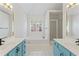 Bright bathroom featuring separate vanities, a soaking tub, and a glass-enclosed shower at 129 Crown Walk, Mcdonough, GA 30253