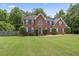 Attractive two-story brick home featuring a lush green lawn and tidy landscaping in a suburban setting at 129 Crown Walk, Mcdonough, GA 30253