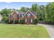 Lovely brick home boasts a spacious front yard, blue shutters and established greenery, offering great curb appeal at 129 Crown Walk, Mcdonough, GA 30253