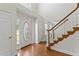 Bright foyer with hardwood floors, a staircase with white railing, and a decorative glass front door at 129 Crown Walk, Mcdonough, GA 30253