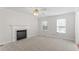 Bright living room with a fireplace, neutral carpet, and large windows creates a comfortable and airy atmosphere at 129 Crown Walk, Mcdonough, GA 30253