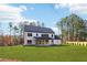 Expansive backyard features manicured lawn and the rear of a two-story home with a covered patio at 3735 Tamiami Trl, Cumming, GA 30041