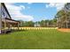Large green backyard shows the exterior of the home with a covered patio and manicured landscaping at 3735 Tamiami Trl, Cumming, GA 30041