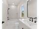 All white bathroom featuring black fixtures, a shower and a large mirror at 3735 Tamiami Trl, Cumming, GA 30041