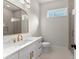 Bright bathroom features white vanity with gold fixtures, arched mirror, and walk-in shower at 3735 Tamiami Trl, Cumming, GA 30041