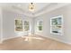 Bright bedroom with light hardwood floors, a tray ceiling, recessed lights and large windows at 3735 Tamiami Trl, Cumming, GA 30041