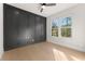 This bedroom features a dark accent wall, large windows and hardwood floors at 3735 Tamiami Trl, Cumming, GA 30041