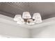 Close up of a stylish chandelier with brass hardware and white lamp shades at 3735 Tamiami Trl, Cumming, GA 30041