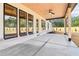 Inviting covered patio with a wood ceiling, ceiling fan, large windows, and a concrete floor at 3735 Tamiami Trl, Cumming, GA 30041