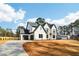 Wide angle shot of a modern two-story home with light brick, dark trim, garage, and large lawn at 3735 Tamiami Trl, Cumming, GA 30041