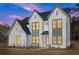 Beautiful modern two-story home with light brick, dark trim, and manicured landscaping at dusk at 3735 Tamiami Trl, Cumming, GA 30041