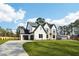 Expansive view of a modern home with a long driveway, complemented by a lush green lawn and mature trees at 3735 Tamiami Trl, Cumming, GA 30041