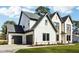 Exterior view showcasing a white brick and panel home with a two-car garage and a pristine, green lawn at 3735 Tamiami Trl, Cumming, GA 30041