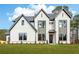 Stunning exterior of a two-story home featuring white brick and modern black-trimmed windows on a lush lawn at 3735 Tamiami Trl, Cumming, GA 30041