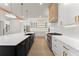 Open kitchen with a large island, stainless steel appliances, white cabinets and modern lighting at 3735 Tamiami Trl, Cumming, GA 30041