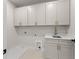 Laundry room with white cabinets and drawers and a gold-tone faucet at 3735 Tamiami Trl, Cumming, GA 30041