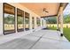Covered patio features stained wood ceiling, ceiling fan, and views of landscaped backyard at 3735 Tamiami Trl, Cumming, GA 30041