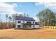 Charming home featuring a covered patio, white siding, black trim, and a large backyard at 3735 Tamiami Trl, Cumming, GA 30041