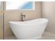 Close-up of a modern soaking tub with chrome hardware and neutral tile background at 3735 Tamiami Trl, Cumming, GA 30041