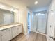 Bathroom featuring a double vanity with granite countertop and a glass-enclosed shower at 5342 Legacy Trl, Douglasville, GA 30135