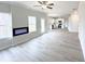Bright, open-concept living room with modern fireplace and wood-look floors flowing into the kitchen at 5342 Legacy Trl, Douglasville, GA 30135