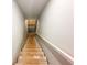 Stairway leading to the unfinished basement with bare wood steps and white painted handrail at 5547 Bent Grass Way, Douglasville, GA 30135