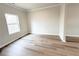 This bedroom features wood flooring, white trim, and a bright window at 5547 Bent Grass Way, Douglasville, GA 30135