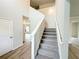 Bright foyer with a carpeted staircase and wood flooring, offering a grand entrance at 5547 Bent Grass Way, Douglasville, GA 30135