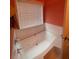 Relaxing soaking tub in a bathroom with white tiles, a window, and a chrome faucet at 582 Georgia Cir, Loganville, GA 30052