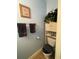 Cozy bathroom featuring a toilet with a cushioned seat, a white shelving unit, and blue walls at 582 Georgia Cir, Loganville, GA 30052