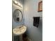 Powder room featuring a pedestal sink, framed mirror, decorative lighting, and a towel rack at 582 Georgia Cir, Loganville, GA 30052