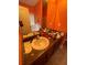 Double sink vanity with decorative fixtures and granite counter top, located in orange-walled bathroom at 582 Georgia Cir, Loganville, GA 30052