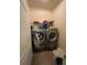 Functional laundry room with a front-load washer, dryer, storage shelf, and neutral tones at 582 Georgia Cir, Loganville, GA 30052