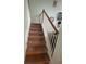 Carpeted stairs with a white banister and wooden handrail leading to the second floor at 582 Georgia Cir, Loganville, GA 30052
