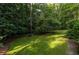 Serene backyard featuring mature trees, lush greenery, and stepping stones, offering a peaceful escape at 1102 Waverly Dr, Lawrenceville, GA 30046