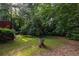 A beautifully landscaped backyard offers a serene retreat with mature trees and green grass at 1102 Waverly Dr, Lawrenceville, GA 30046