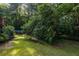 Lush backyard featuring mature trees and a glimpse of the above-ground pool, providing a private oasis at 1102 Waverly Dr, Lawrenceville, GA 30046
