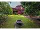 Spacious backyard featuring a fire pit, lush lawn, and wooded privacy, perfect for outdoor entertaining at 1102 Waverly Dr, Lawrenceville, GA 30046