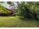 Spacious backyard with a lush lawn, mature trees, and a charming deck, perfect for relaxation and entertaining at 1102 Waverly Dr, Lawrenceville, GA 30046