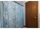 Bathroom featuring a blue patterned shower curtain and wood door at 1102 Waverly Dr, Lawrenceville, GA 30046