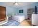 Comfortable bedroom with light blue walls, a ceiling fan, and a bookshelf at 1102 Waverly Dr, Lawrenceville, GA 30046