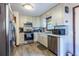 Modern kitchen with stainless steel appliances, white cabinetry, and gray wood-look flooring at 1102 Waverly Dr, Lawrenceville, GA 30046