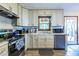 Well-lit kitchen with stainless steel appliances, white cabinets, unique backsplash and view to exterior at 1102 Waverly Dr, Lawrenceville, GA 30046