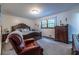 Generous main bedroom featuring dark wood bedframe, reading chair and dresser at 1102 Waverly Dr, Lawrenceville, GA 30046