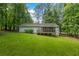 Home with screen porch nestled in a backyard with mature trees at 1154 Pinebrook Rd, Auburn, GA 30011