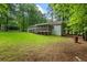 A deck at the back of a house overlooks a spacious backyard and surrounding trees at 1154 Pinebrook Rd, Auburn, GA 30011