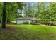 Backyard view features a home with a deck, surrounded by lush trees at 1154 Pinebrook Rd, Auburn, GA 30011
