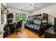 Bright bedroom featuring wooden floors, ceiling fan, desk, and bunk beds at 1154 Pinebrook Rd, Auburn, GA 30011