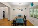 An open concept dining room with wood floors, white wainscoting, and large windows at 1154 Pinebrook Rd, Auburn, GA 30011